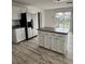 Kitchen with white cabinets, island, laminate countertops, and stainless steel refrigerator at 14598 E Evans Ave, Aurora, CO 80014