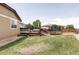 Backyard showcasing a wooden deck, trampoline, and an expansive lawn, ideal for recreation at 3972 S Shawnee Way, Aurora, CO 80018