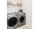 Modern laundry room with stainless steel washer and dryer, complemented by practical shelving above at 3972 S Shawnee Way, Aurora, CO 80018