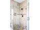 Modern shower with pebble flooring, glass door, and stylish tile accents at 3972 S Shawnee Way, Aurora, CO 80018