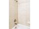 Shower area showcasing neutral-colored tiles, updated showerhead, and pristine bathtub at 3972 S Shawnee Way, Aurora, CO 80018
