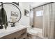 Modern bathroom featuring stylish vanity with a round mirror, tiled shower, and modern fixtures at 1045 W 101St Ave, Northglenn, CO 80260