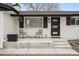 Inviting front porch with chairs, a black front door, and a white brick facade at 1045 W 101St Ave, Northglenn, CO 80260