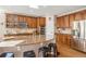 An open kitchen with a granite countertop island, wood cabinets, and stainless steel appliances at 1828 Aquamarine Ct, Castle Rock, CO 80108