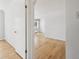 A bright view of a hallway leading into a bedroom with hardwood floors and white walls at 1130 N Pennsylvania St # 208, Denver, CO 80203