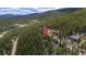 Heavily wooded mountain homesite with a nearby home and winding dirt road access at 542 Harris Dr, Idaho Springs, CO 80452
