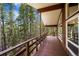 Expansive covered balcony showcasing a serene forest view and natural light from the large windows at 542 Harris Dr, Idaho Springs, CO 80452
