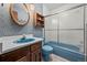 Retro bathroom features blue fixtures, wood accents and a shower over a tub with sliding glass doors at 542 Harris Dr, Idaho Springs, CO 80452