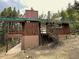 A charming cabin with wood siding, large deck, concrete pad, and set amongst the trees at 542 Harris Dr, Idaho Springs, CO 80452