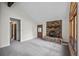Open living room featuring a rustic stone fireplace and modern gray carpeting at 542 Harris Dr, Idaho Springs, CO 80452