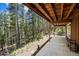 Covered patio offering serene outdoor living and entertaining surrounded by lush forest at 542 Harris Dr, Idaho Springs, CO 80452