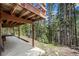 Covered patio with wood beams is an idyllic setting for outdoor enjoyment and relaxation in the woods at 542 Harris Dr, Idaho Springs, CO 80452