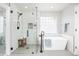Bright, updated bathroom with glass shower, soaking tub, modern fixtures, and mosaic tile at 907 Eldorado Dr, Superior, CO 80027