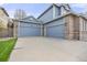 Attached two car garage with blue doors, brick accents, and a spacious driveway for easy parking at 907 Eldorado Dr, Superior, CO 80027
