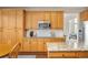 Well-lit kitchen with wood cabinets, stainless steel microwave, granite countertops, and hardwood flooring at 907 Eldorado Dr, Superior, CO 80027