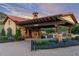 Elegant gated entrance with a stone facade, clock tower, and beautifully landscaped grounds at 8033 Galileo Way, Littleton, CO 80125