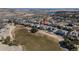 An aerial view of a well-maintained neighborhood nestled on a golf course with mountain views at 8033 Galileo Way, Littleton, CO 80125