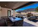 Inviting covered outdoor living space with a fire pit, dining table, and mountain views at 8033 Galileo Way, Littleton, CO 80125