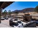 Inviting outdoor patio with stone fireplace and comfortable seating, perfect for enjoying the serene mountain views at 8033 Galileo Way, Littleton, CO 80125