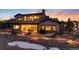 Elegant home with a large patio, outdoor fireplace, seating area, and manicured landscaping at 8033 Galileo Way, Littleton, CO 80125