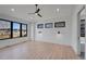 Spacious primary bedroom with three windows, ceiling fan, and light hardwood floors at 804 Spyglass Cir, Louisville, CO 80027