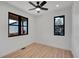 Bright bedroom featuring two windows, ceiling fan, and light wood flooring at 804 Spyglass Cir, Louisville, CO 80027