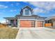 Modern home with a spacious driveway, wooden garage doors, and beautiful curb appeal at 804 Spyglass Cir, Louisville, CO 80027