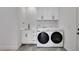 Well-lit laundry room featuring modern washer and dryer, sleek cabinets, and a utility sink at 804 Spyglass Cir, Louisville, CO 80027