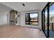 Living room featuring stone fireplace, large window, and glass sliding door to the backyard at 804 Spyglass Cir, Louisville, CO 80027