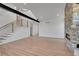 Bright living room with stone fireplace, wood flooring, and staircase with wood and black metal railings at 804 Spyglass Cir, Louisville, CO 80027