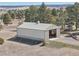 Aerial shot of property showing a metal outbuilding with open door set amidst trees and beautiful landscape at 2287 Pinto Trl, Elizabeth, CO 80107