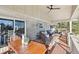Covered wooden deck with a ceiling fan, outdoor dining table, and comfortable lounge seating at 2287 Pinto Trl, Elizabeth, CO 80107