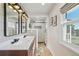 Modern bathroom with double sinks, a glass enclosed shower, and natural light from the window at 2287 Pinto Trl, Elizabeth, CO 80107