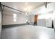 Spacious garage with epoxy flooring, storage cabinets and an access door at 2287 Pinto Trl, Elizabeth, CO 80107