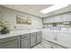 Functional laundry room with gray cabinets, marble countertop, a washing machine, and a dryer at 2287 Pinto Trl, Elizabeth, CO 80107