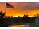 Captivating landscape showcasing a fiery sunset sky over the lush treetops and the American Flag at 2287 Pinto Trl, Elizabeth, CO 80107