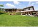 Expansive backyard featuring lush green lawn, complemented by a covered patio and pergola, perfect for outdoor living at 3720 Ranch Hand Ln, Castle Rock, CO 80104