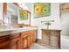 Well-lit bathroom with wood cabinets, a tile backsplash, and a framed mirror at 3720 Ranch Hand Ln, Castle Rock, CO 80104