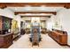 Elegant dining room with detailed trim, beams, stone fireplace, and multiple antique furnishings at 3720 Ranch Hand Ln, Castle Rock, CO 80104