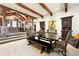 Spacious dining area featuring exposed beams, stone accents, and elegant furnishings adjoining the home's entrance at 3720 Ranch Hand Ln, Castle Rock, CO 80104