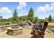Inviting stone fire pit with Adirondack chairs and waterfall feature, perfect for outdoor entertaining and enjoying scenic views at 3720 Ranch Hand Ln, Castle Rock, CO 80104