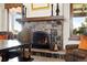 Cozy stone fireplace with rustic mantel in an elegant room, complemented by stylish chairs and decor at 3720 Ranch Hand Ln, Castle Rock, CO 80104
