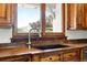 Close-up of the kitchen sink and counter, showcasing the unique wood cabinetry and natural light at 3720 Ranch Hand Ln, Castle Rock, CO 80104
