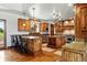 Well-appointed kitchen with wood floors, wood cabinets, stainless appliances, and an island with seating at 3720 Ranch Hand Ln, Castle Rock, CO 80104