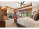Tranquil bedroom with stone fireplace, access to outdoor views, and wood ceiling detail at 3720 Ranch Hand Ln, Castle Rock, CO 80104