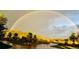 A gorgeous, scenic shot of a home with a rainbow spanning across the backyard at 3720 Ranch Hand Ln, Castle Rock, CO 80104