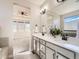 Bathroom with dual sinks and modern fixtures, connecting seamlessly to the main bedroom with large windows at 23709 E Caleb Pl, Aurora, CO 80016