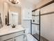 Bright bathroom featuring a vanity with white countertop and a modern glass-enclosed shower at 23709 E Caleb Pl, Aurora, CO 80016