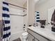 Clean bathroom featuring a shower-tub combination with a blue-striped curtain, a gray vanity, and modern fixtures at 23709 E Caleb Pl, Aurora, CO 80016