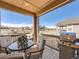 Relaxing covered deck with outdoor dining set and grill overlooking the neighborhood at 23709 E Caleb Pl, Aurora, CO 80016